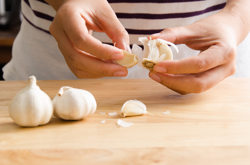 Woman peeling a head of garlic
