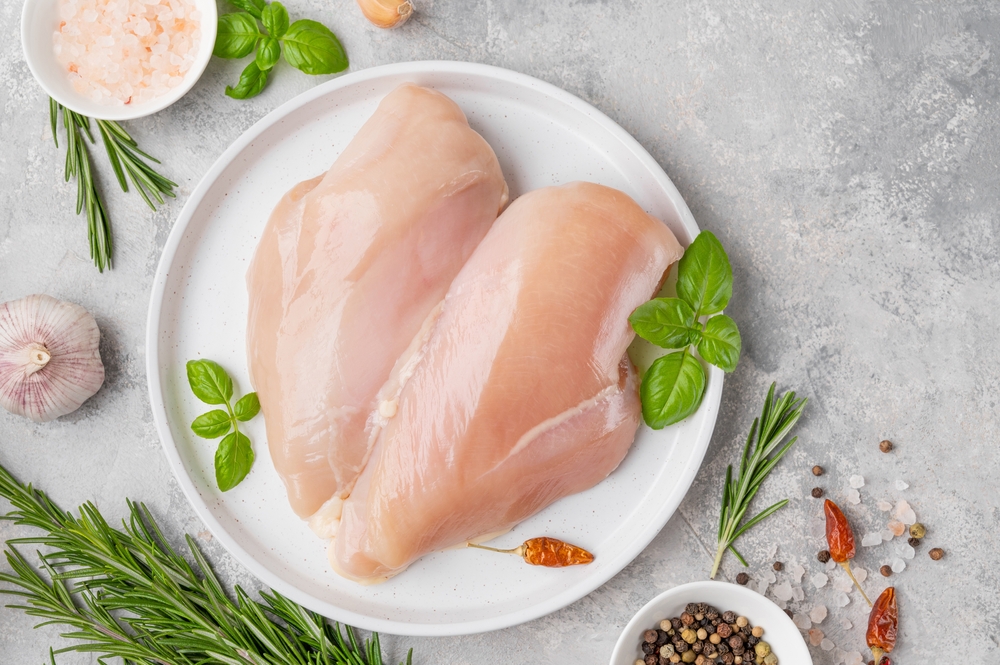Raw chicken breasts on a platter